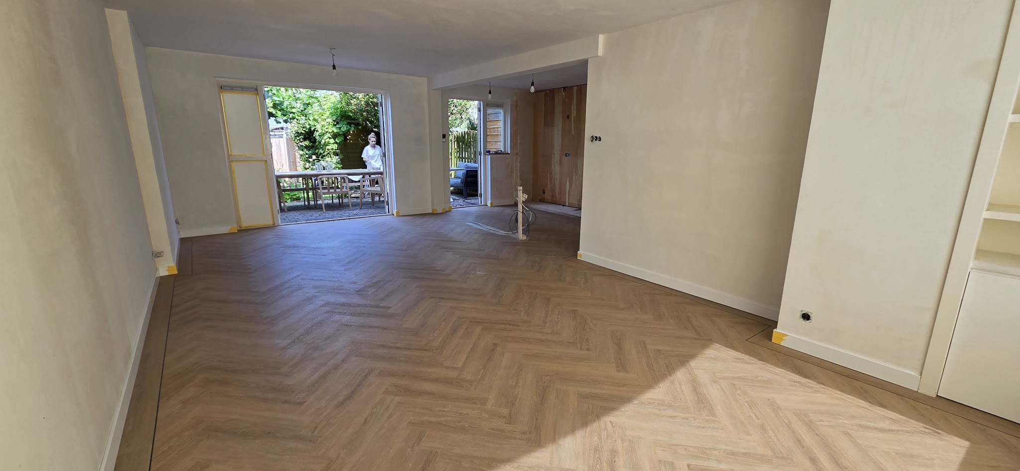 Een lichte doorzonkamer met een visgraatvloer