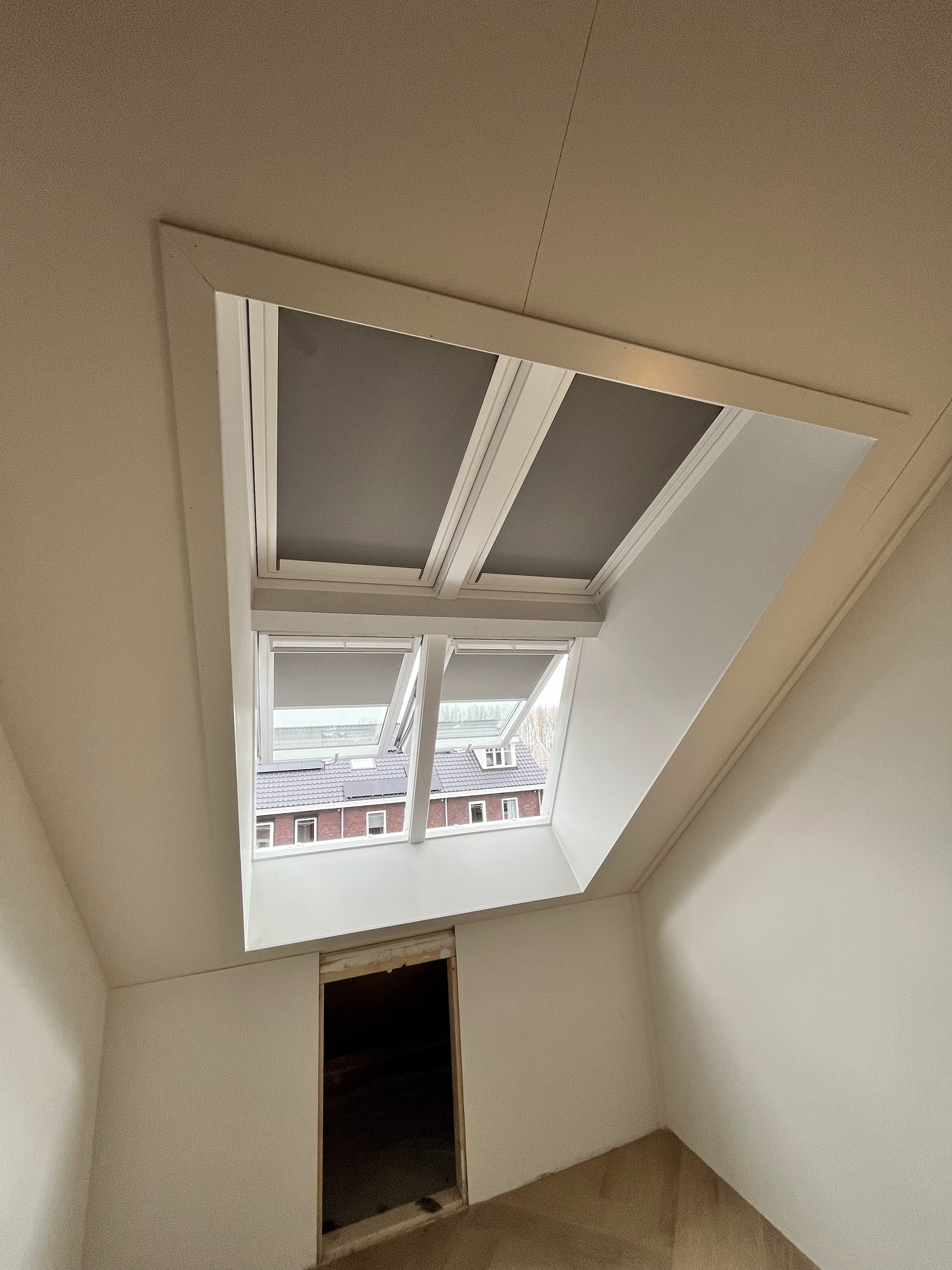 Een zolderkamer met twee dakramen in een nieuw afgewerkte lichtkoker